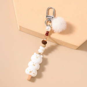 Détail du porte-clés ours avec boule de fourrure pelucheuse et crochet argenté