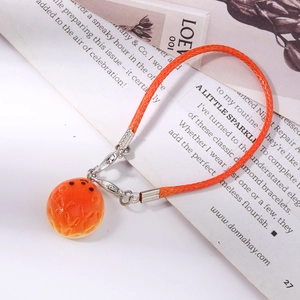 Close-up of cute orange pineapple bun charm with woven lanyard and metal clasp