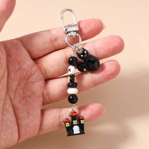 Handheld Halloween keychain featuring black cat and castle charms with beaded details