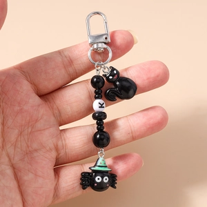 Detail of Halloween beaded keychain with black cat charm and green spider pendant