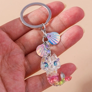 Detail of glitter resin mermaid cat keychain with shells and iridescent sequins