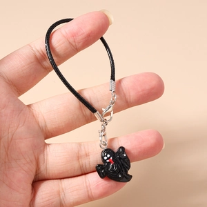 Detail of Halloween phone strap featuring a black ghost charm and silver lobster clasp