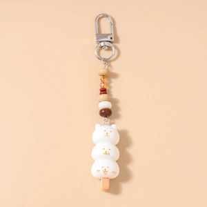 Détail d'un porte-clés perlé avec trois pendentifs mignons en forme de chats blancs dango