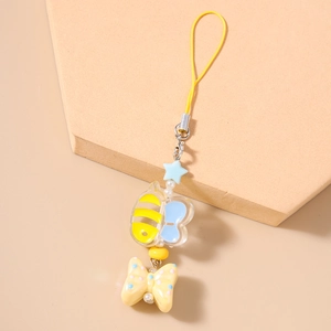 Close-up of cute bee pendant and polka dot bow detail on the cartoon phone charm