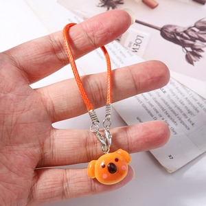 Close-up of bright orange koala resin pendant with matching braided lanyard cord