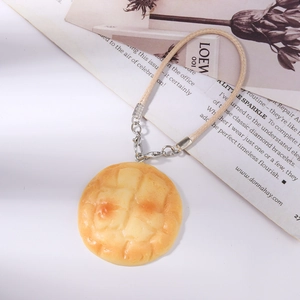 Detail of realistic melon pan charm with braided strap and silver lobster clasp accessory