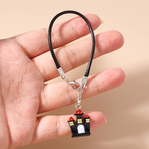 Close-up of a woven phone strap featuring a colorful cartoon castle charm for Halloween