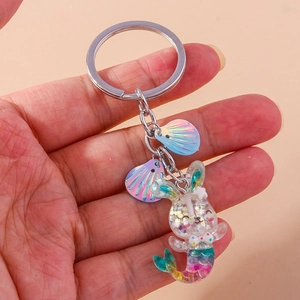 Detail of glitter mermaid rabbit keychain with holographic shell charms and silver ring