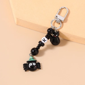 Detail of Halloween beaded keychain featuring black spider, cat charms and initial bead