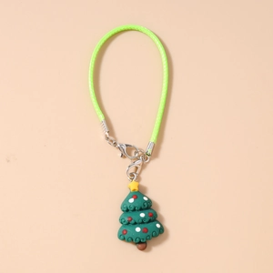Detail of Christmas tree charm with green lanyard and silver lobster clasp on beige base