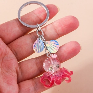 Cute octopus keychain with pink crown and iridescent shells on a glitter resin charm