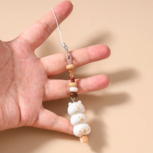 Détail d'un bijou de téléphone dango mignon en forme d'ours avec perles et fermoir mousqueton