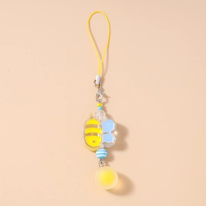 Detail of yellow bee charm with blue acrylic parts and decorative faceted beads