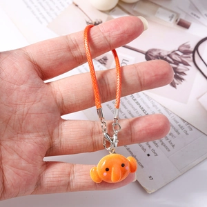 Detail of an orange blobfish charm with a woven lanyard and silver lobster clasp