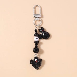 Detail of Halloween keychain featuring black cat and ghost charms with beaded chain