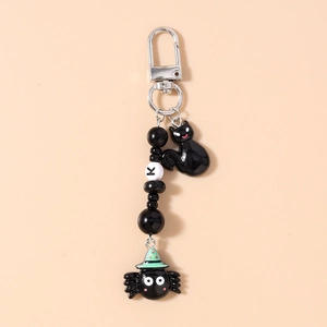 Detail of Halloween keychain featuring black beads, letter K, cat and spider charms