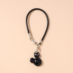 Detail of a black woven lanyard with a polished cat pendant for phone or bag charm