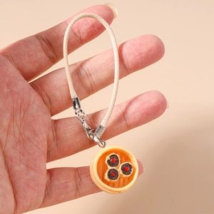 Close-up of realistic siu mai food charm in a mini steamer with woven lanyard strap