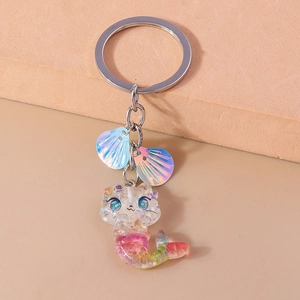 Detail view of a cat mermaid keychain with colorful glitter resin and shell charms