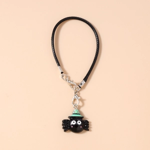 Detail of cartoon black spider phone charm with green hat on black braided strap