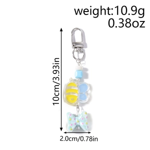 Detail view of cartoon bee and bow keychain showing size and weight specifications