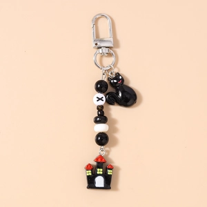 Detail of Halloween keychain with black cat, castle pendant, and beaded charms