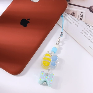 Detail of blue butterfly and bee acrylic bead charm hanging on a red phone case