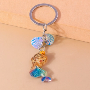 Detailed macro view of a glittery resin mermaid keychain with seashell charms