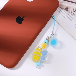 Detailed view of yellow bee and blue butterfly beaded phone charm on a mobile case