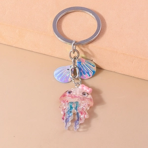 Detail of pink resin jellyfish keychain with iridescent shells and metallic ring