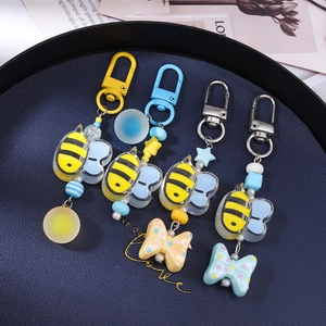 Set of four cute cartoon bee beaded keychains with colorful bows and star charms