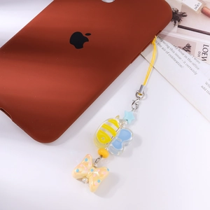 Detail of bee and heart bead phone charm with polka dot bow and yellow strap