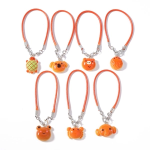 Set of seven cartoon animal charms including koala and elephant with orange woven cords