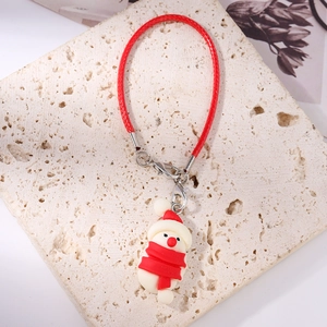 Detailed close-up of a festive snowman phone charm with red lanyard on stone base