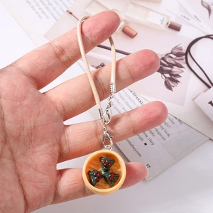 Detailed close-up of a handmade food dumpling steamer keychain with leather cord strap