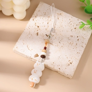 Vue détaillée d'un pendentif dango ours blanc à trois niveaux avec perles et cordon