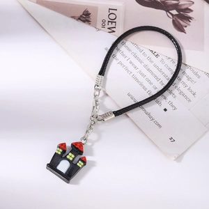 Detail of Halloween black castle phone charm with red roof and silver lobster clasp
