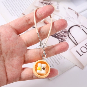 Detail of creative Chinese dim sum steamer pendant with woven cord and lobster clasp