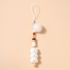 Détail d'un pendentif d'ours blanc mignon avec pompon en fausse fourrure et perles
