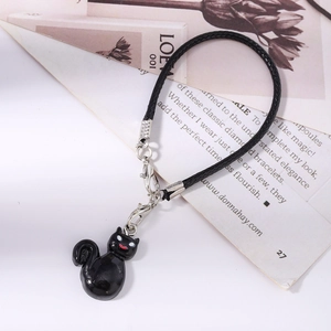 Detail of black cat charm with silver lobster clasps and braided phone lanyard accessory