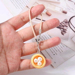 Detail of creative mini steam bun charm with beige woven cord and silver metal clasp