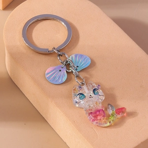 Detail of mermaid cat resin keychain with shimmering shell charms and a silver key ring