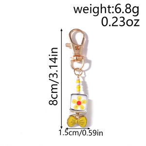 Detail showing dimensions of beaded goldfish keychain with bow pendant and floral cube
