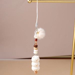Détail d'un charmant pendentif de sac avec boule en peluche et perles colorées
