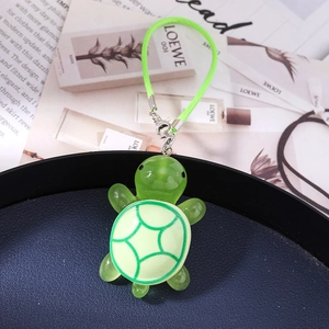 Detail of green resin turtle charm with cross pattern shell on a luxury blue display tray
