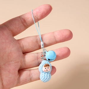 Close-up of a blue cartoon peanut character charm with a matching bell and blue wrist strap