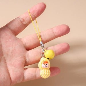 Detail of creative cartoon peanut charm with bell and yellow lanyard for mobile phones