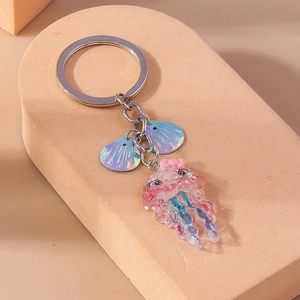 Detail of a pink jellyfish keychain with shimmering blue shell charms on a metal ring