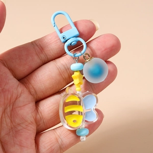 Detail of beaded keychain with blue lobster clasp and yellow striped honeybee charm