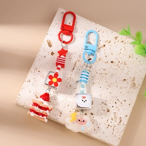 Détail de porte-clés colorés en résine avec pendentifs gâteau fraise et nuage